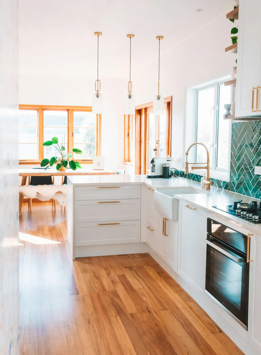 Bright kitchen with white cabinets, pendant lights and wood floors