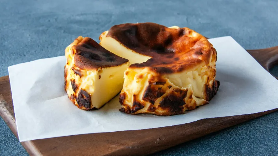 Burnt basque cheesecake cut open on baking paper