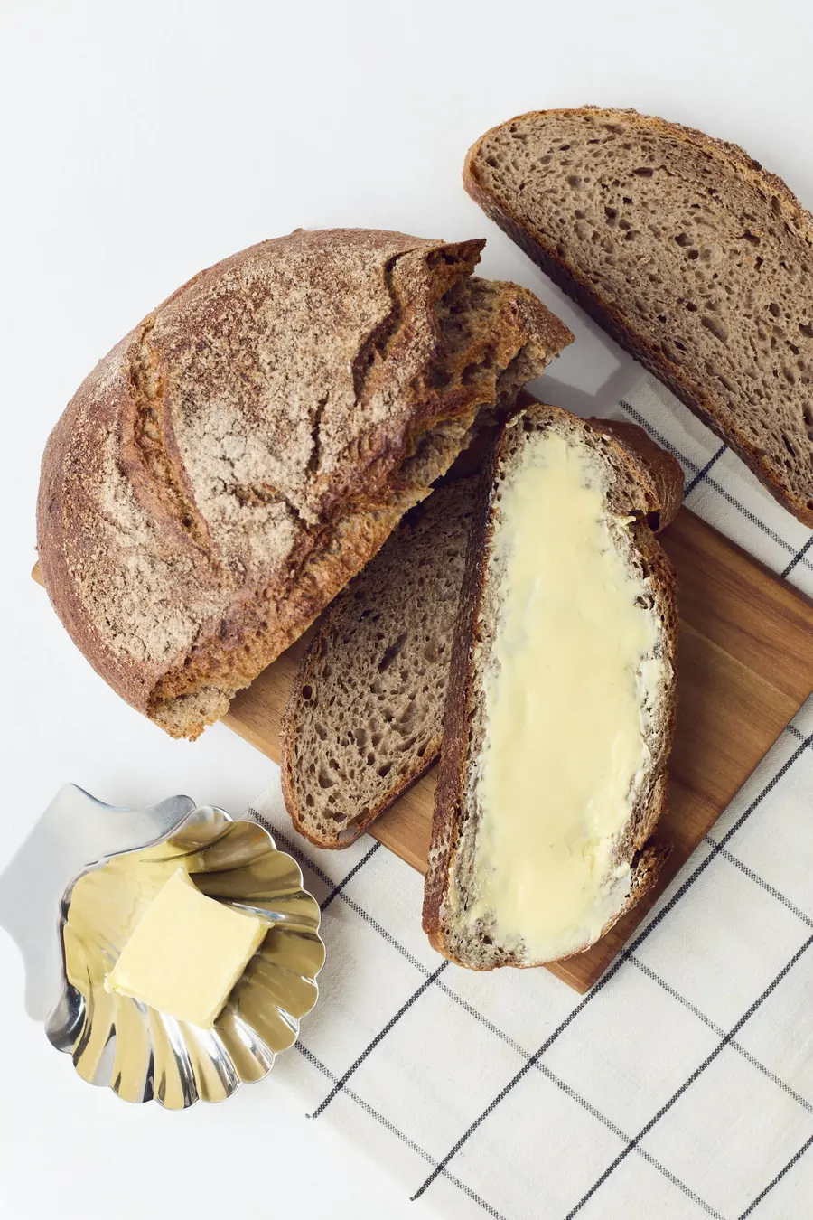 Sourdough loaf with a thick slice spread with butter
