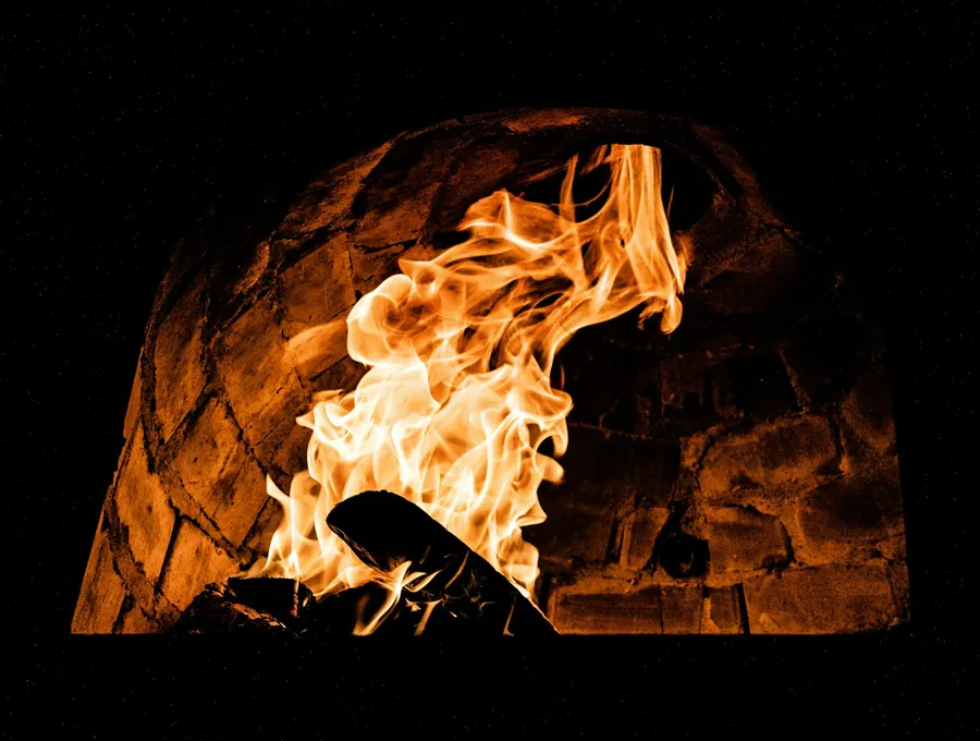 Oak logs burning inside a brick wood-fire oven
